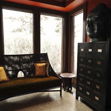 This inner city, heritage home front entry overlooks the city. Expansive windows original to the entry, Crema Marfil and Nero Marquina mosaic marble tile floors nod to the age and character of the home. The red walls, gold glazed ceiling, McGuire bench, antique chest, side tables and bronze Buddah head make this spacious entry warm and welcoming. 